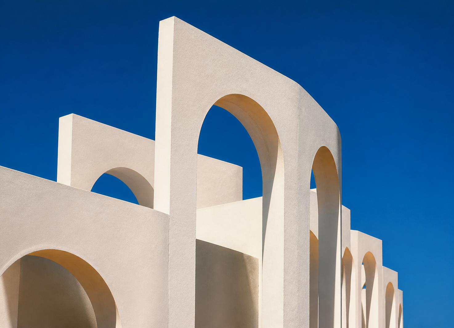 White geometric arches under a blue sky